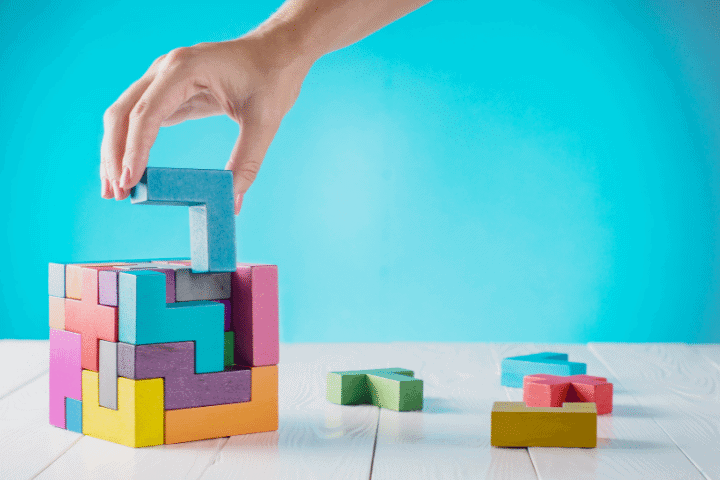 marketing in your boardroom is being demonstrated by wooden executive toy block, the final piece being put in