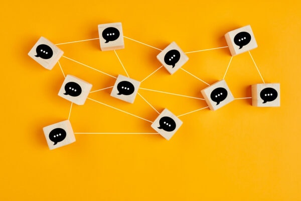 The concept is "well planned content" it has been represented by a yellow back ground with wooden blocks connected by strings. the wooden blocks have a black speach bubbles on them