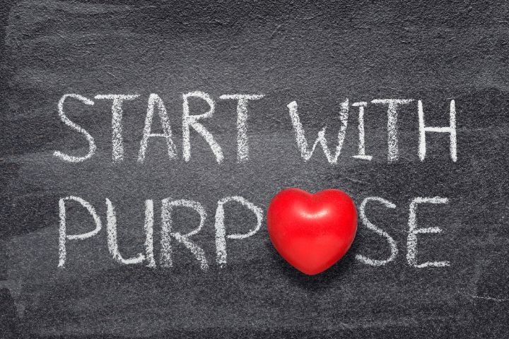 Concept for purpose led businesses using social media. image depicts a chalkboard that has white writing on it "Start with a purpose" the "O" of "Purpose" is replaced with a large red heart.