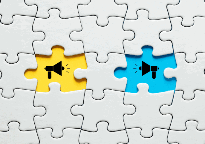 jigsaw puzzle with two missing pieces and the background is blue and yellow with megaphones