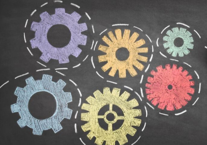 A person drawing gears on a blackboard.